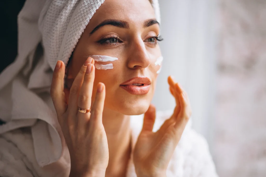 Chica aplicándose protector solar facial antes de salir