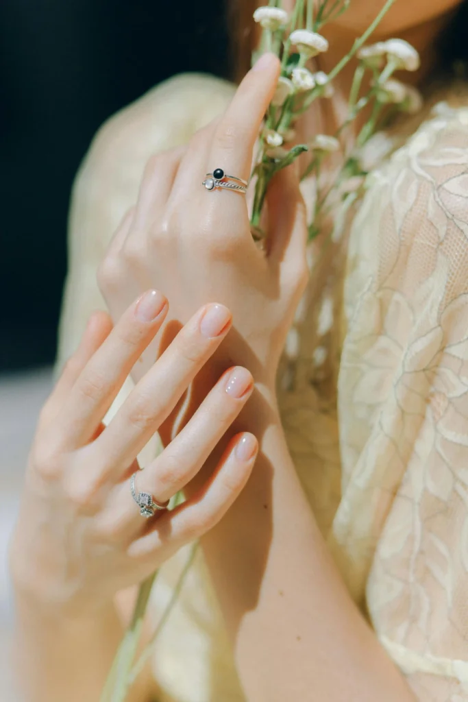 Estilo de uñas y maquillaje que reflejan una belleza elegante y natural.