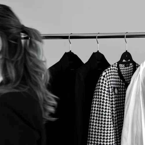 Fotografía en blanco y negro de mujer observando un armario cápsula minimalista