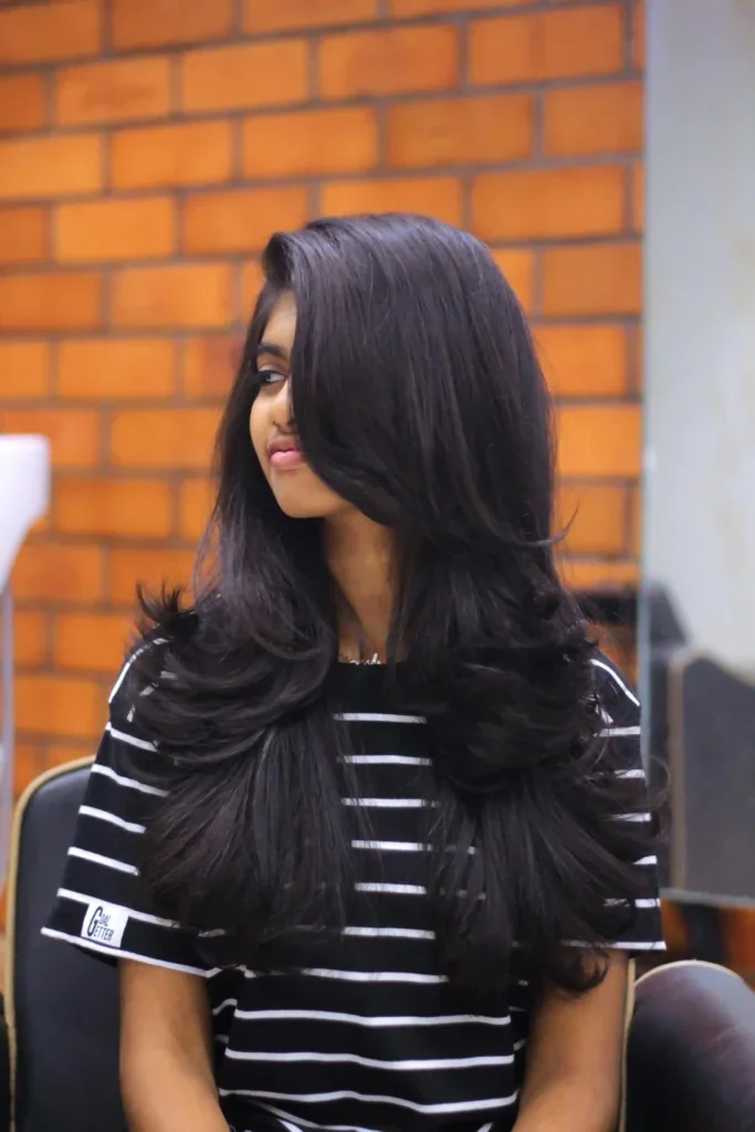 Mujer con corte mariposa de capas voluminosas en cabello negro largo
