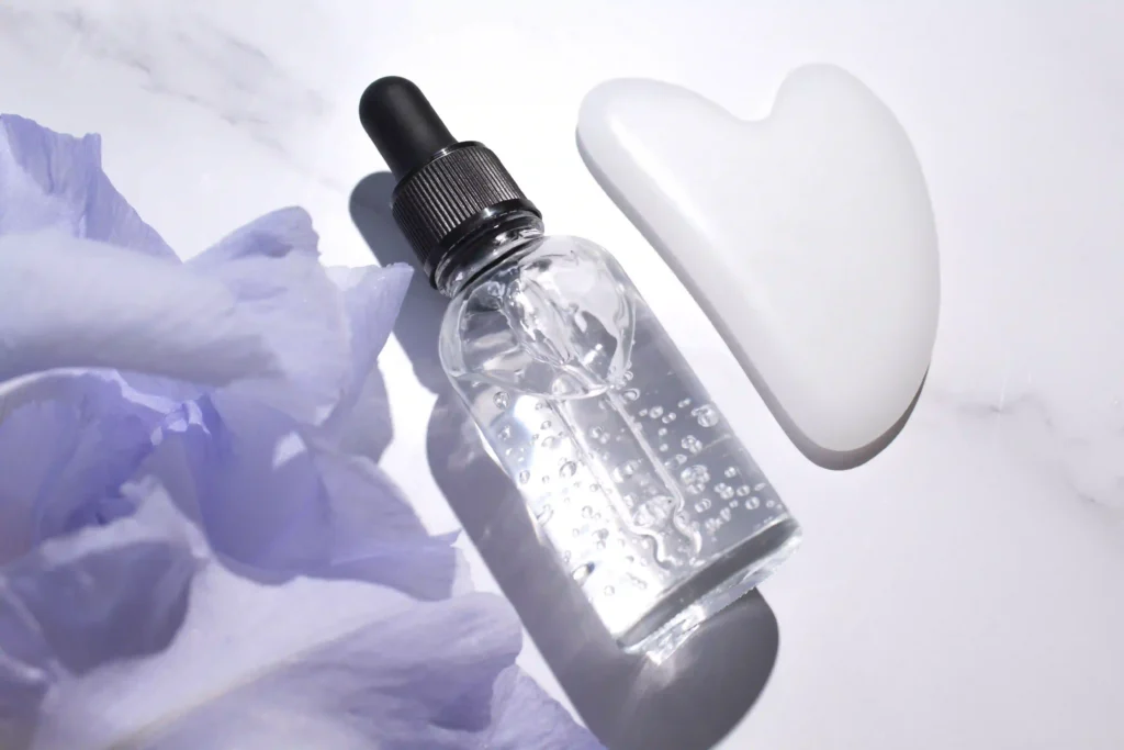 Sérum con extractos florales acompañado de piedra gua sha para mejorar textura y luminosidad de la piel.