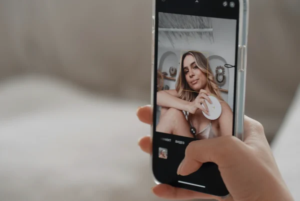 Persona sosteniendo un teléfono mientras toma una selfie con un filtro de belleza aplicado.