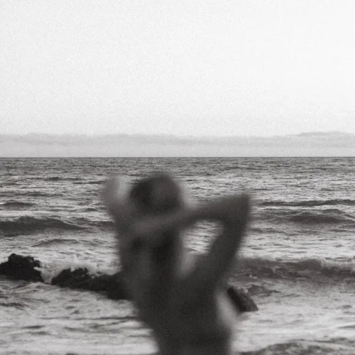 Persona contemplando el mar, simbolizando introspección y conexión con la belleza interior