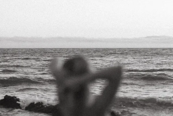 Persona contemplando el mar, simbolizando introspección y conexión con la belleza interior