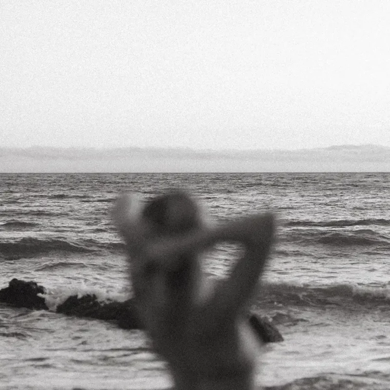 Persona contemplando el mar, simbolizando introspección y conexión con la belleza interior