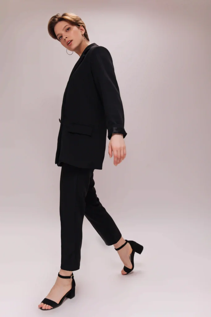 Mujer con traje negro elegante, una alternativa moderna al vestido para eventos tipo cóctel.