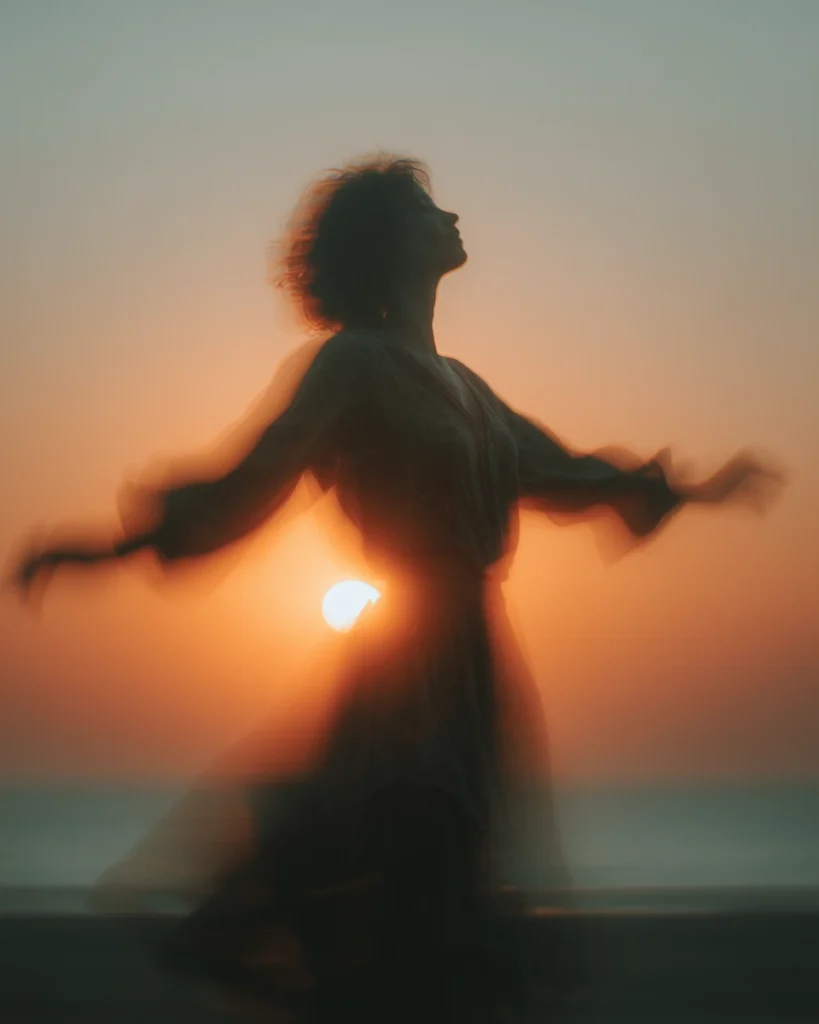 Silueta femenina bailando al atardecer simbolizando libertad y expresión auténtica.
