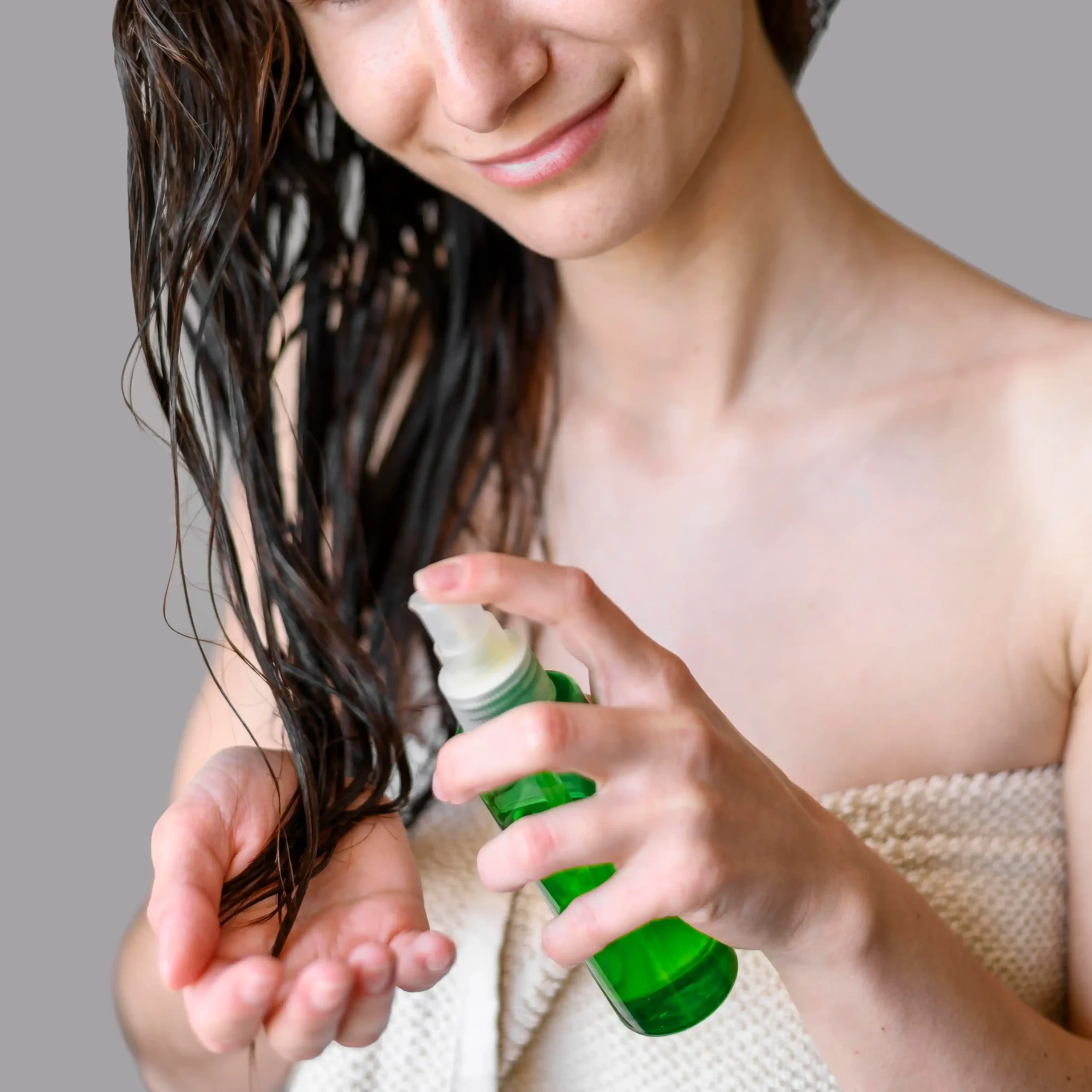 Mujer joven aplicándose serum en su melena