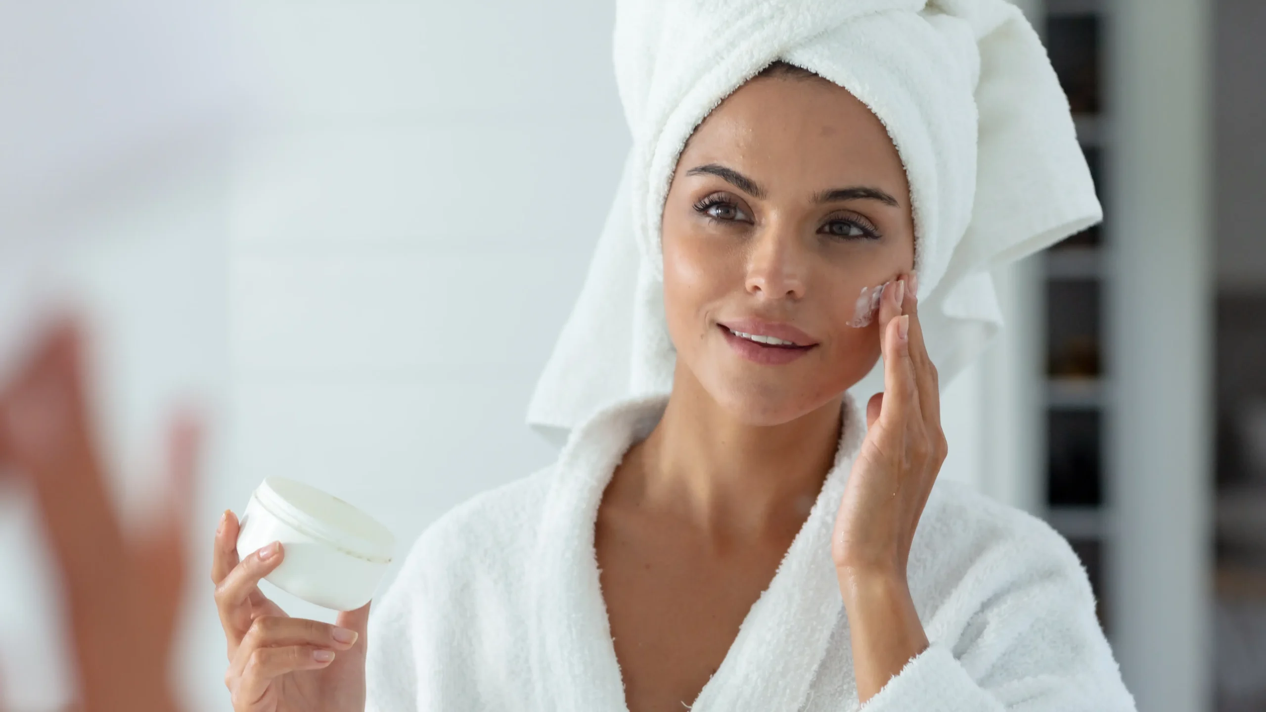 Mujer aplicándose cremas hidratantes para evitar la piel seca