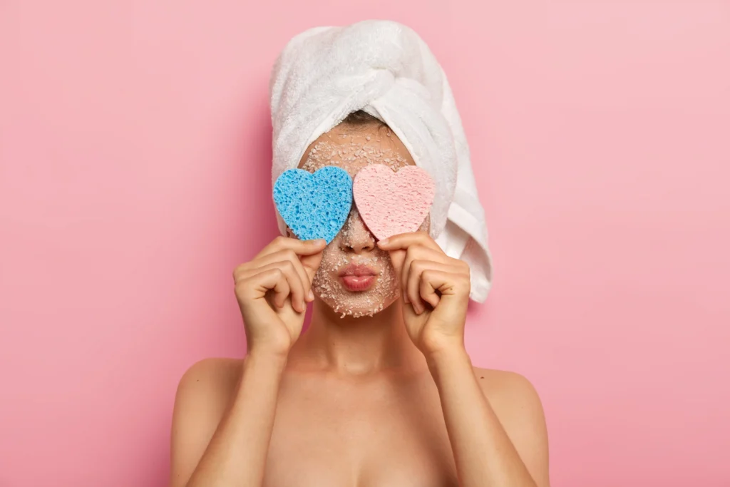 Mujer joven con scrub en su rostro para limpieza facial