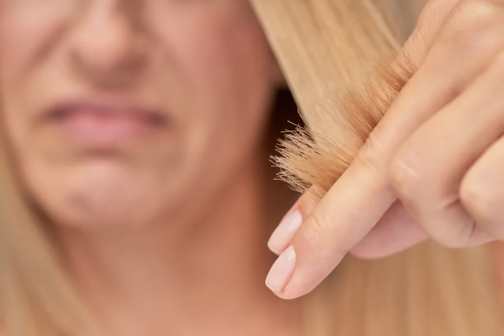Mujer rubia con las puntas abiertas de su melena