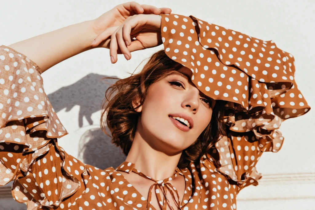 Blusa marrón con lunares blancos y mangas con volantes para looks de primavera verano