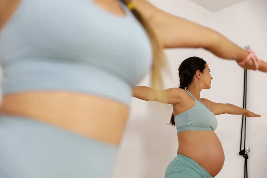Mujer embarazada practicando yoga suave como hábito saludable durante la gestación.