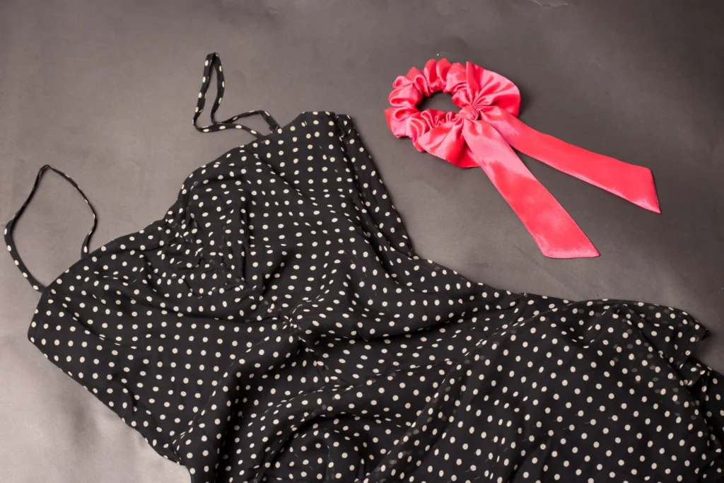 Vestido negro de lunares blancos con coletero rojo, inspiración polka dots para accesorios
