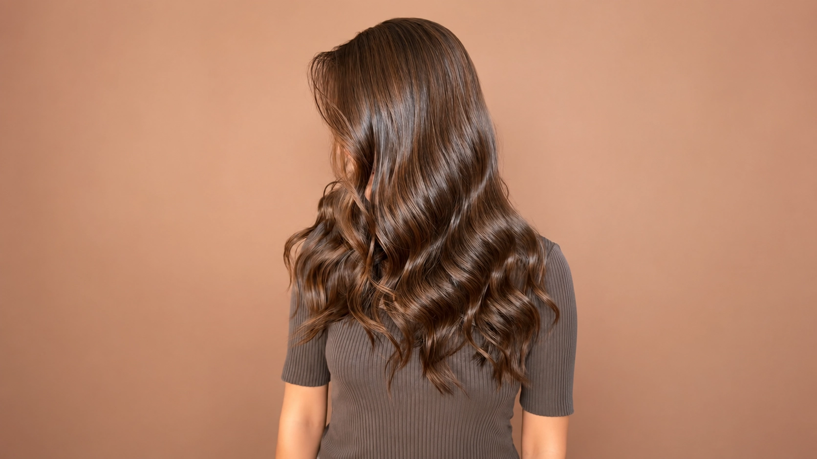 Mujer de espaldas con Color de pelo avellana ondulado y brillante