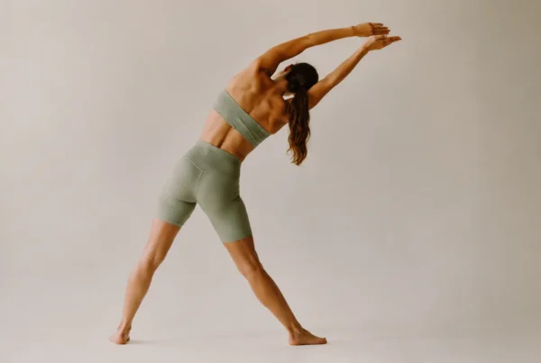 Mujer realizando estiramientos espalda con inclinación lateral y brazos extendidos