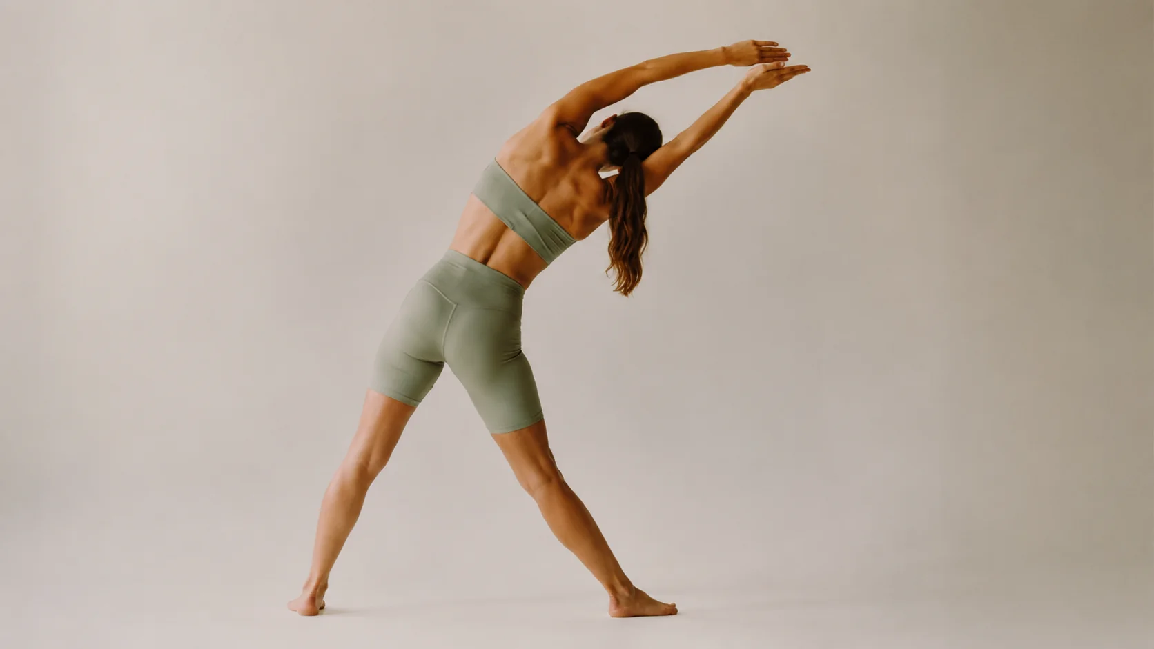 Mujer realizando estiramientos espalda con inclinación lateral y brazos extendidos