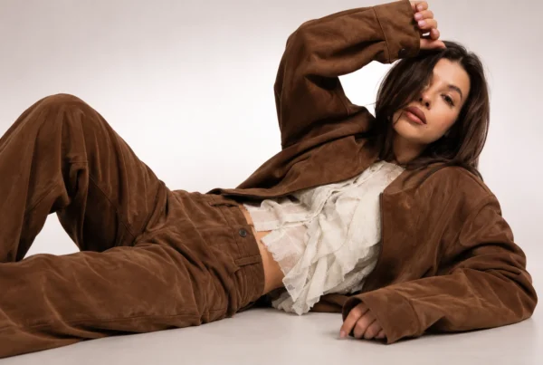 Mujer con chaqueta mujer marrón de ante y blusa blanca de encaje en una sesión editorial de moda